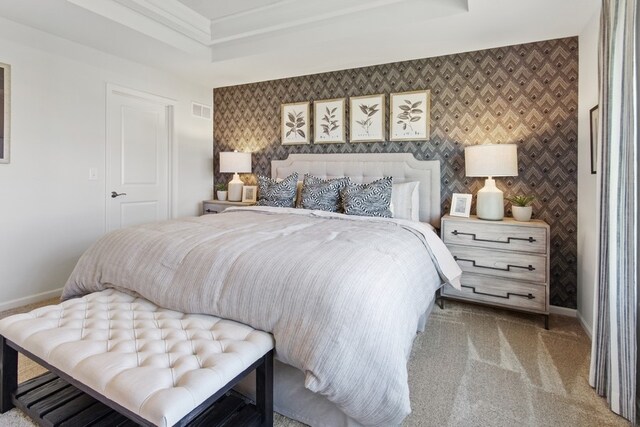 bedroom featuring light colored carpet and a tray ceiling