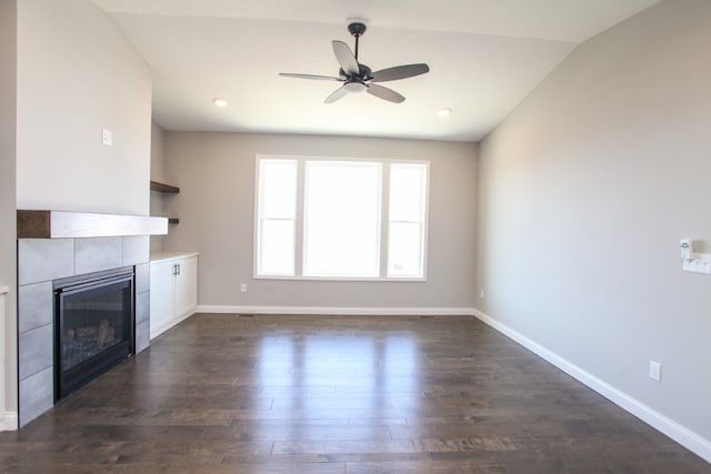 unfurnished living room featuring vaulted ceiling, ceiling fan, a fireplace, and dark hardwood / wood-style floors