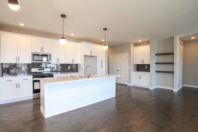 kitchen with appliances with stainless steel finishes, white cabinetry, pendant lighting, and dark wood-type flooring