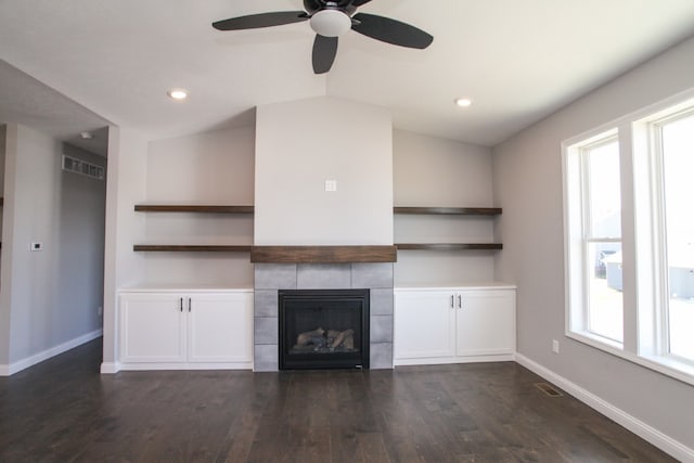 unfurnished living room featuring dark hardwood / wood-style flooring, ceiling fan, vaulted ceiling, and a wealth of natural light