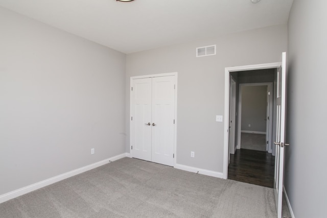 unfurnished bedroom with a closet and dark carpet