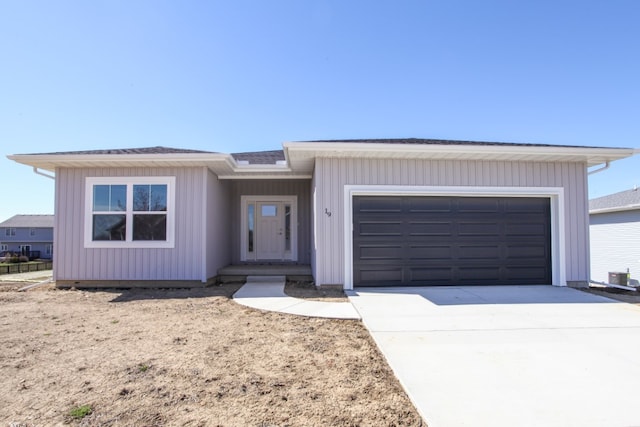 view of front of house with a garage and central air condition unit