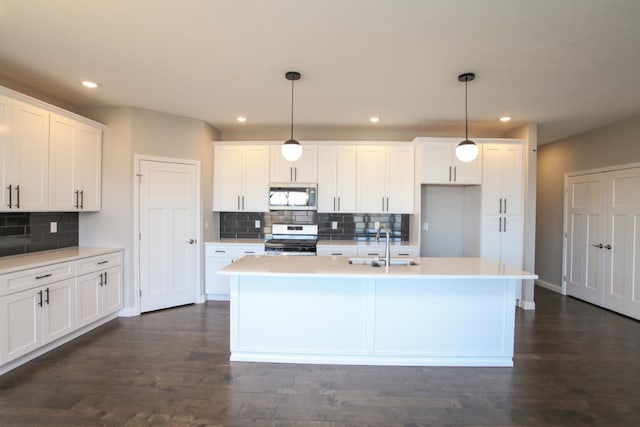 kitchen with pendant lighting, dark wood-type flooring, stainless steel appliances, and white cabinets