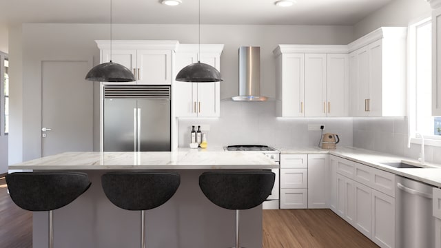 kitchen featuring sink, appliances with stainless steel finishes, wall chimney exhaust hood, tasteful backsplash, and white cabinetry