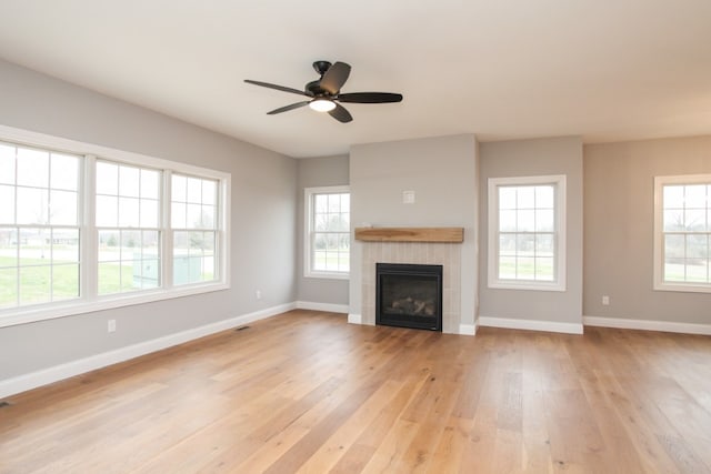 unfurnished living room with a fireplace, light hardwood / wood-style flooring, and ceiling fan