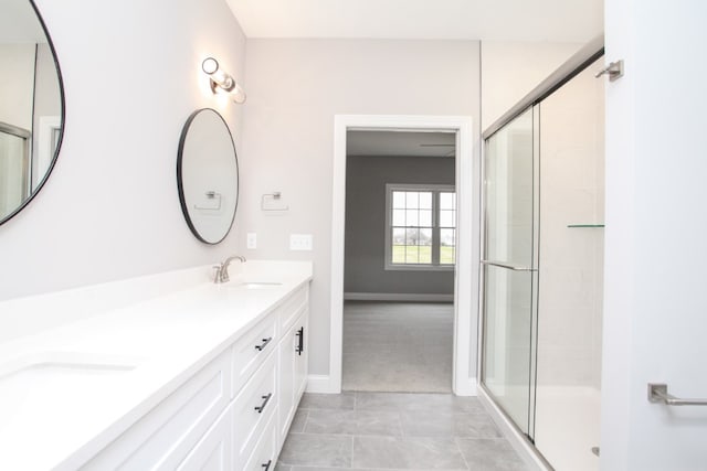 bathroom featuring tile floors, a shower with shower door, and dual bowl vanity