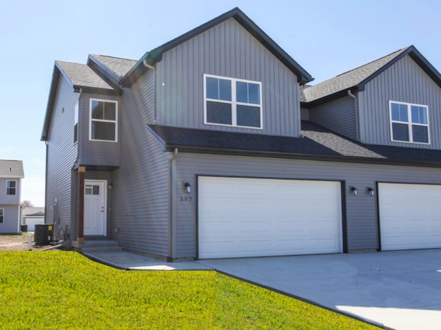 view of front of home with central AC unit, a front lawn, and a garage