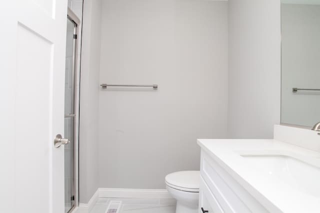 bathroom with walk in shower, toilet, tile floors, and vanity