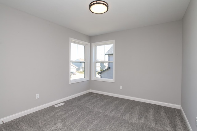 unfurnished room with dark carpet