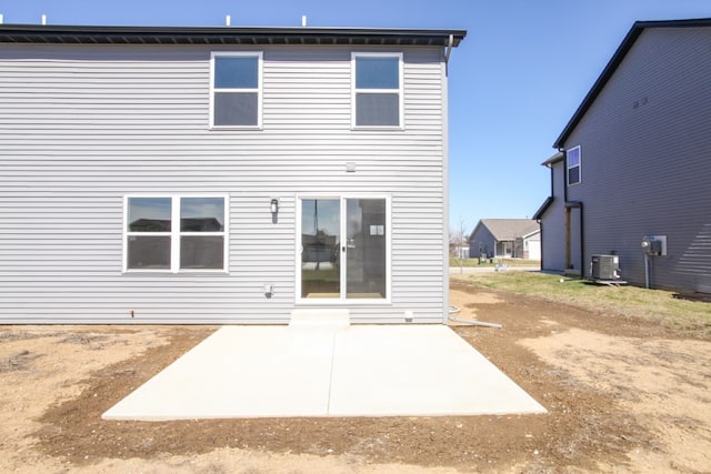 rear view of house with central AC and a patio