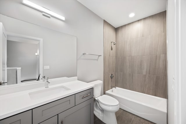 full bathroom featuring toilet, tile floors, tiled shower / bath combo, and vanity