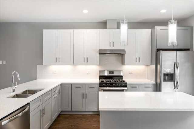 kitchen featuring dark hardwood / wood-style flooring, decorative light fixtures, sink, and stainless steel appliances