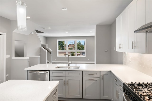 kitchen with pendant lighting, stainless steel dishwasher, tasteful backsplash, gray cabinets, and sink