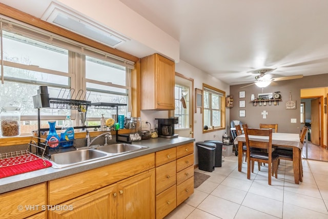 kitchen featuring light tile patterned floors, ceiling fan, and a sink