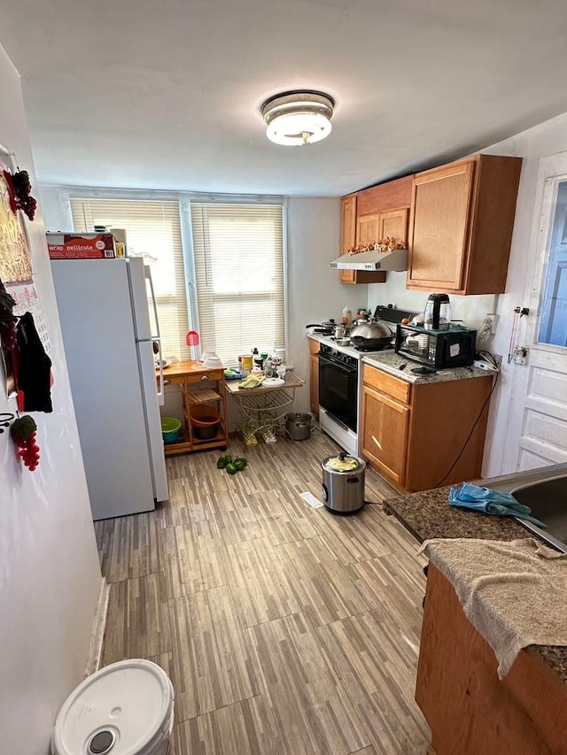 kitchen featuring light hardwood / wood-style floors and white appliances