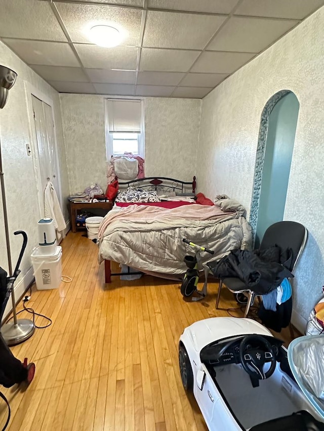 bedroom featuring pool table, a drop ceiling, and light wood-type flooring