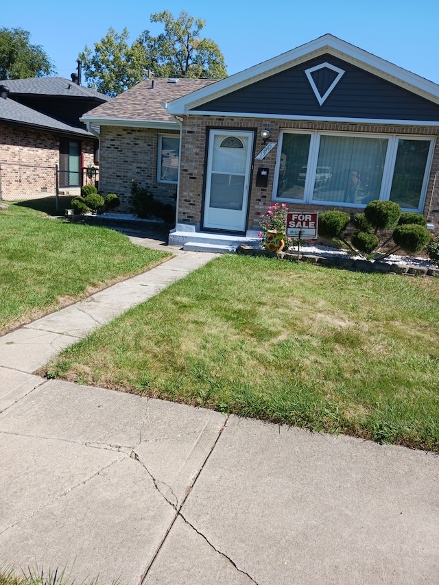 single story home featuring a front lawn