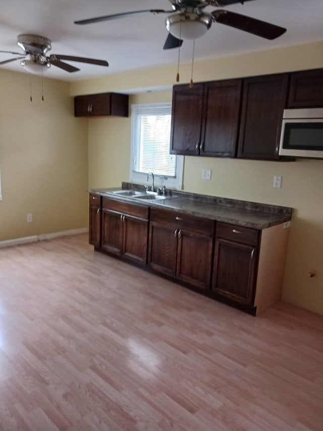 kitchen with ceiling fan, dark brown cabinets, light hardwood / wood-style floors, and sink