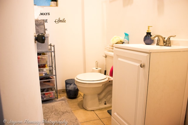 bathroom with tile flooring, toilet, and vanity