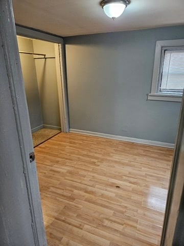 unfurnished bedroom with light wood-type flooring and a closet