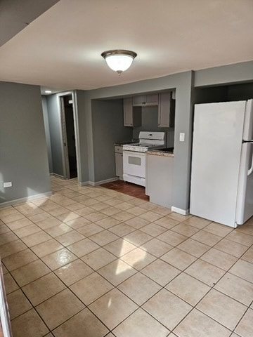 kitchen featuring gray cabinetry, white appliances, and light tile floors