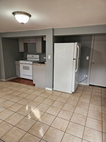 kitchen featuring white appliances and light tile floors