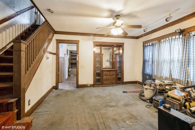 unfurnished living room with rail lighting, ornamental molding, and ceiling fan