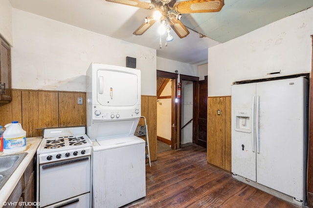 kitchen featuring dark hardwood / wood-style floors, stacked washer and clothes dryer, ceiling fan, white appliances, and sink