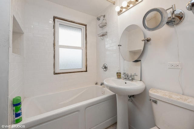 bathroom featuring toilet and tiled shower / bath