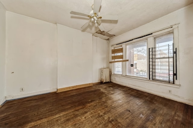 spare room featuring radiator heating unit, ceiling fan, and dark wood-type flooring