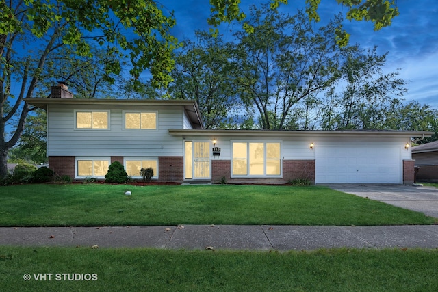 split level home featuring a lawn and a garage