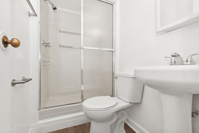 bathroom featuring toilet, hardwood / wood-style floors, and walk in shower