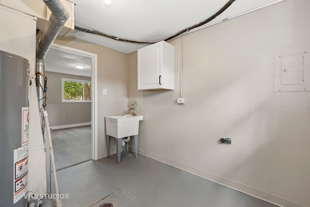 laundry room featuring sink, gas water heater, and cabinets