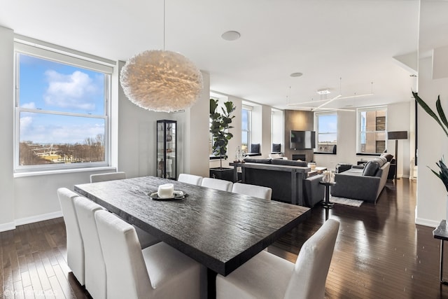 dining space featuring dark hardwood / wood-style flooring, floor to ceiling windows, and plenty of natural light