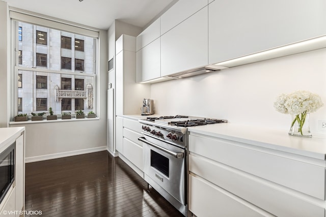 kitchen featuring premium stove, plenty of natural light, dark wood-type flooring, and white cabinets