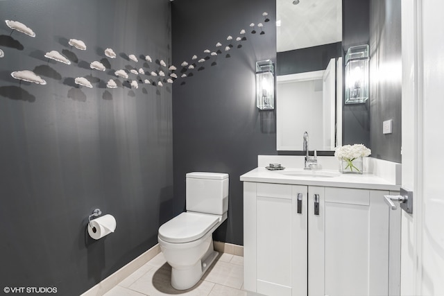 bathroom with toilet, large vanity, and tile floors