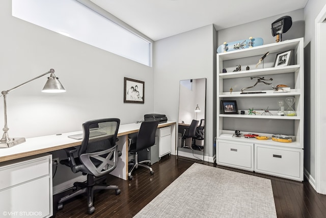 office space with built in desk and dark hardwood / wood-style flooring