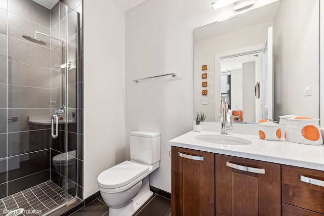 bathroom featuring oversized vanity, tile floors, a shower with shower door, and toilet