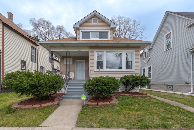 bungalow-style home with covered porch and a front lawn