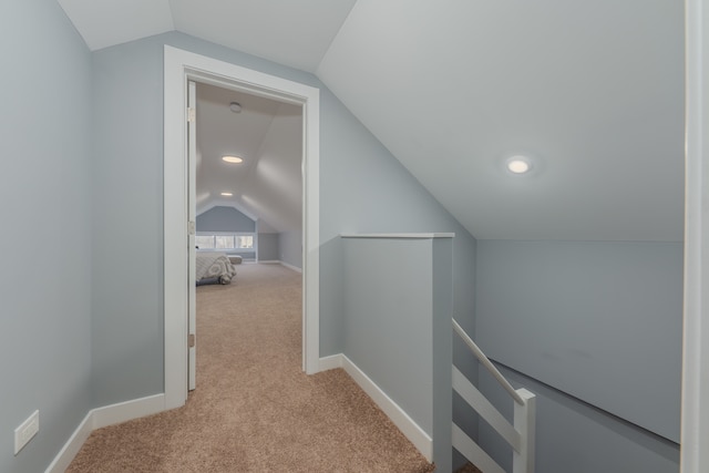 additional living space featuring light colored carpet and vaulted ceiling