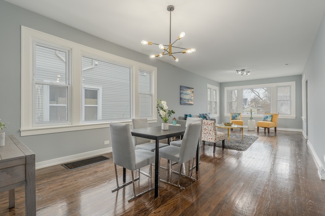 dining space featuring a notable chandelier and dark wood-type flooring