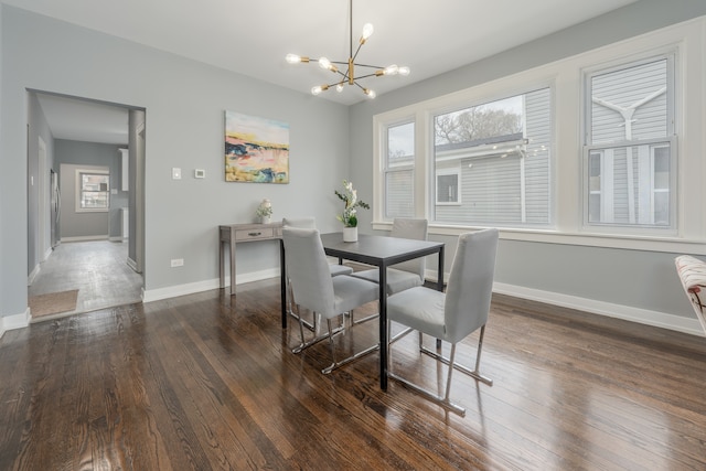 dining area with dark hardwood / wood-style flooring, a notable chandelier, and plenty of natural light