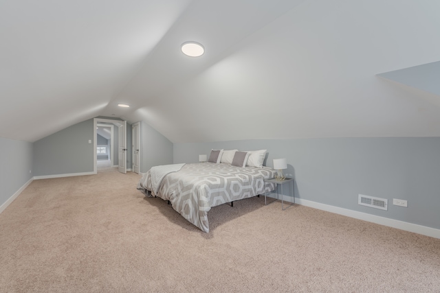 bedroom featuring lofted ceiling and light colored carpet