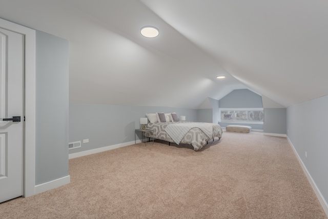 unfurnished bedroom featuring vaulted ceiling and light colored carpet