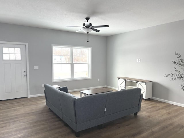 living room with dark hardwood / wood-style flooring, a textured ceiling, ceiling fan, and a wealth of natural light