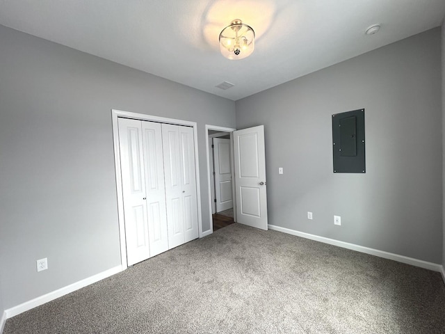 unfurnished bedroom with electric panel, a closet, and carpet flooring