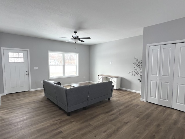 living room featuring a healthy amount of sunlight, dark wood-type flooring, and ceiling fan