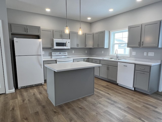 kitchen with sink, a kitchen island, white appliances, and gray cabinets