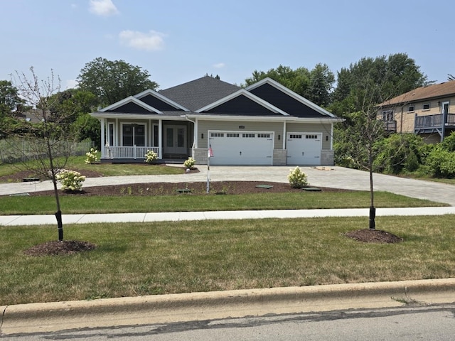 craftsman inspired home with a garage and a front lawn