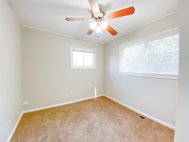 spare room featuring light colored carpet, plenty of natural light, and ceiling fan